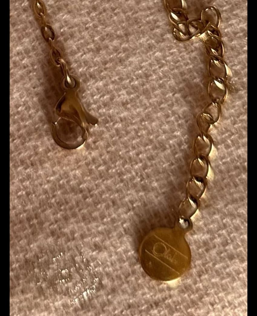 Bijoux or et acier disposés sur fond noir chaud